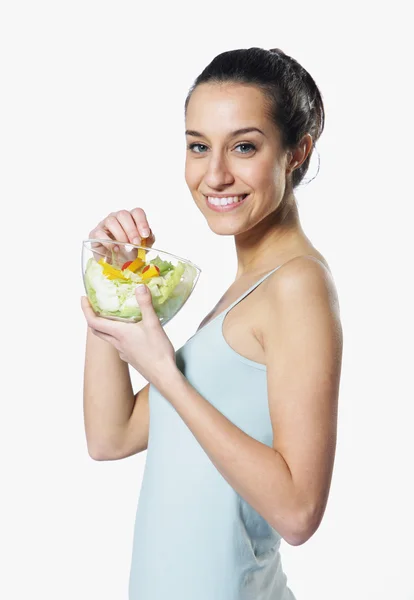Κοπέλα που κρατά το πιάτο με σαλάτα σε άσπρο φόντο — Φωτογραφία Αρχείου