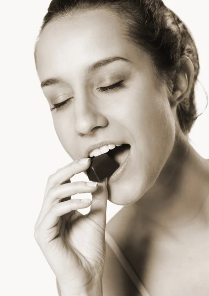 Porträt einer schönen jungen Frau, die Schokolade isst — Stockfoto