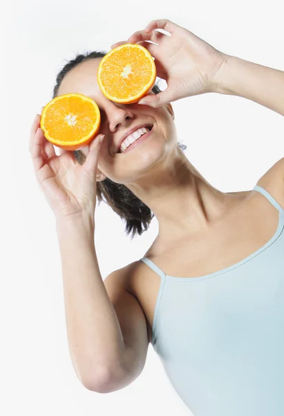 Legrační portrét, drží pomeranče nad očima, dieta koncepce — Stock fotografie