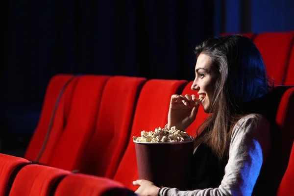 Portrait of a pretty young woman, she eats popcorn and smiles — Stock Photo, Image