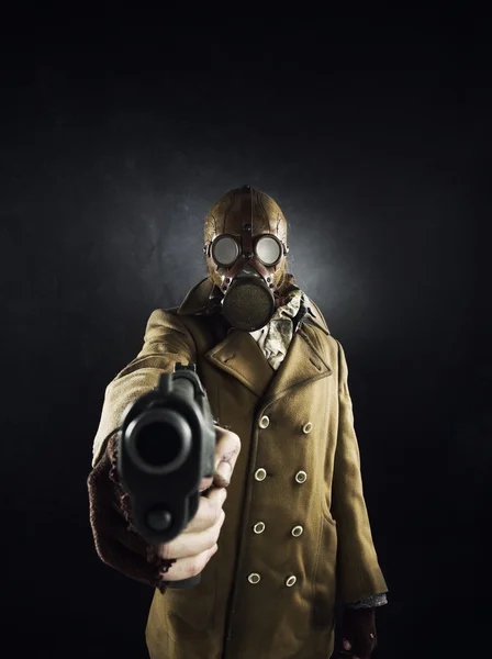 Grunge portrét muž v plynové masce míří pistolí — Stock fotografie