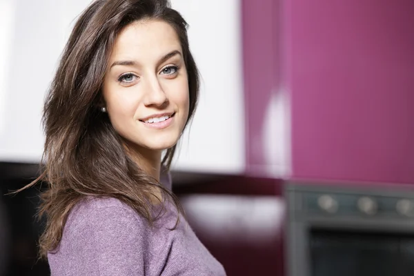 Portrait of beautiful young woman in kitchen — Stock Photo, Image