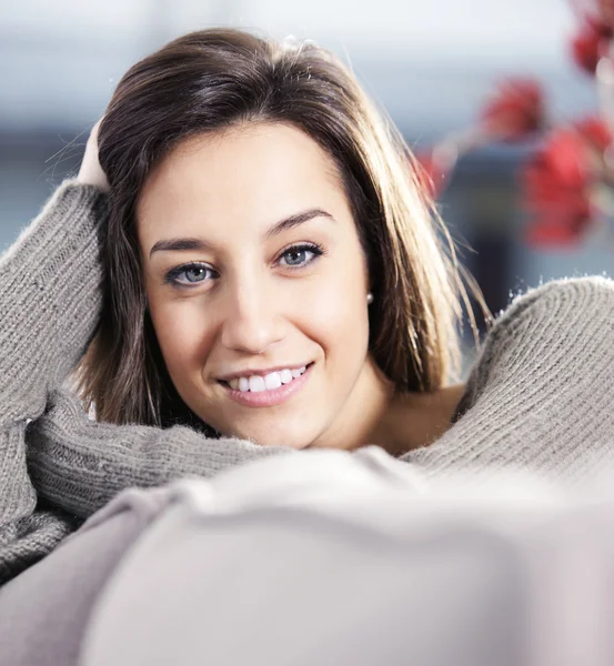 Portrait of a beautiful young woman on couch — Stock Photo, Image