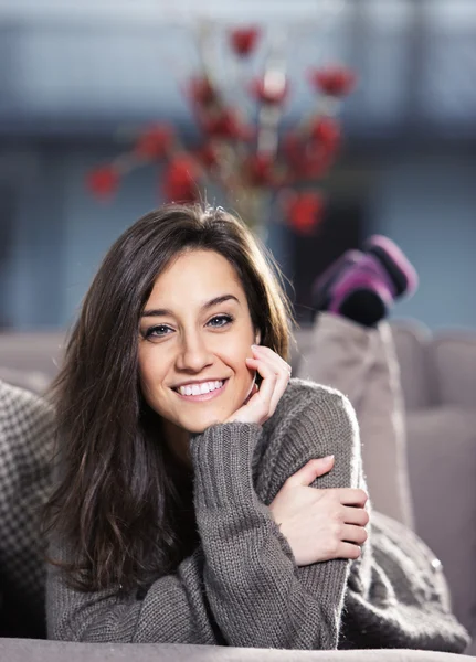Portrait of a beautiful young woman lying on couch — Stock Photo, Image