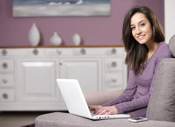 Portret młodej kobiety na kanapie przy użyciu laptopa — Zdjęcie stockowe