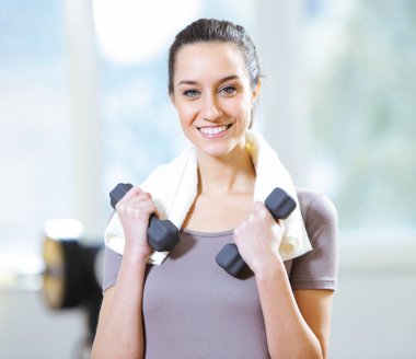 Dumbbell in hand of working out young smiling female clipart