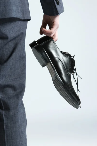 Uomo d'affari che tiene le scarpe in mano, vicino — Foto Stock