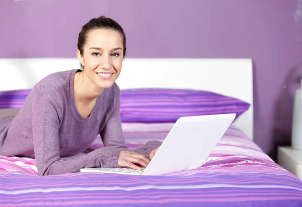 Dizüstü bilgisayar kullanırken genç bir kadın — Stok fotoğraf