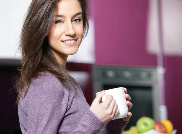 Mulher tomando café na cozinha — Fotografia de Stock