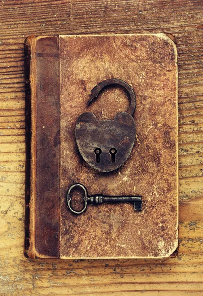 Antique Padlock with key on old book — Stock Photo, Image