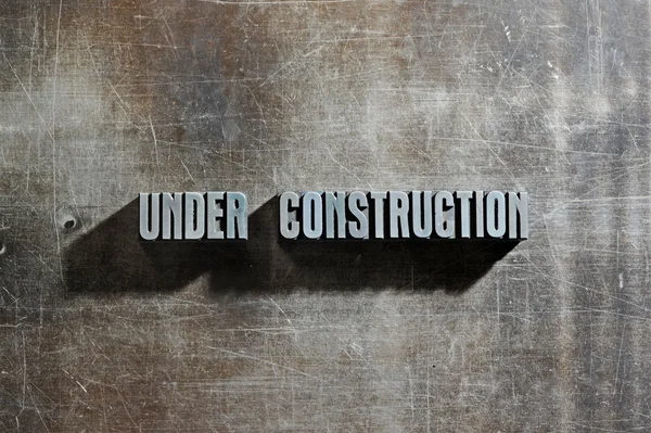Image of a Under Construction sign with a metallic background te — Stock Photo, Image