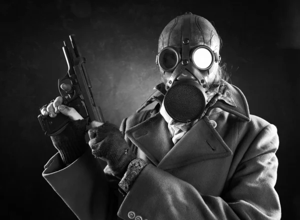 Grungeportrettmann i gassmaske med pistol – stockfoto