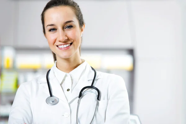 V lékárně. usměvavá mladá žena lékárník s stetoskop — Stock fotografie