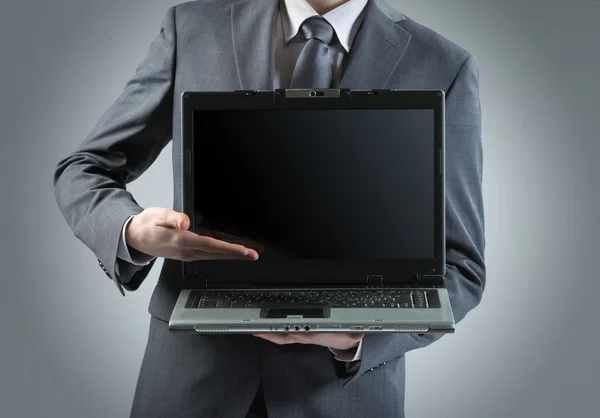 Empresario sosteniendo su portátil — Foto de Stock
