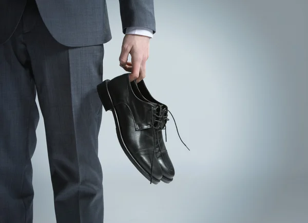 Businessman holding the shoes in hand, close up — Stock Photo, Image