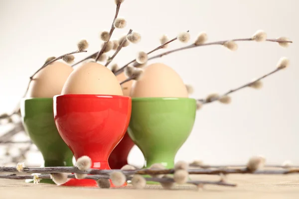 Eier in roten und grünen Eierbechern — Stockfoto