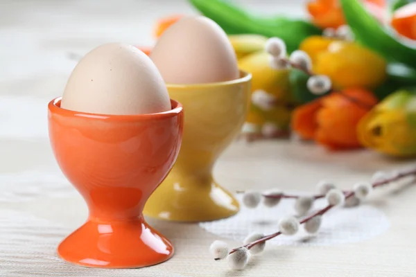 Eier in orangen und gelben Eierbechern — Stockfoto