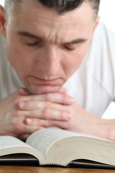 Человек, молящийся с Библией Лицензионные Стоковые Изображения