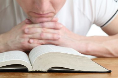 Man praying with the Bible clipart