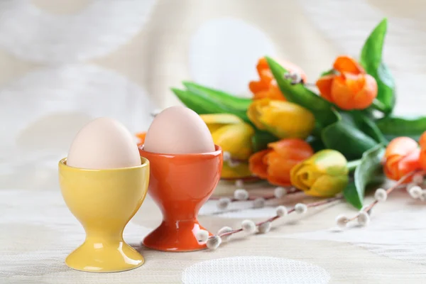 Eieren in oranje en gele eggcups — Stockfoto