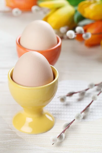 Eier in orangen und gelben Eierbechern — Stockfoto