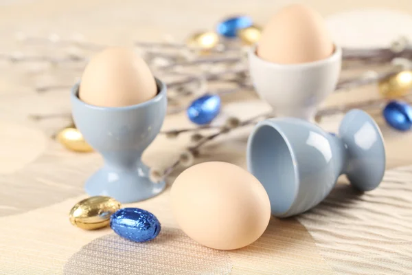 Ovos em copos de ovo brancos e azuis — Fotografia de Stock
