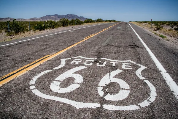 Largo camino con un inicio de sesión Ruta 66 pintado en él — Foto de Stock