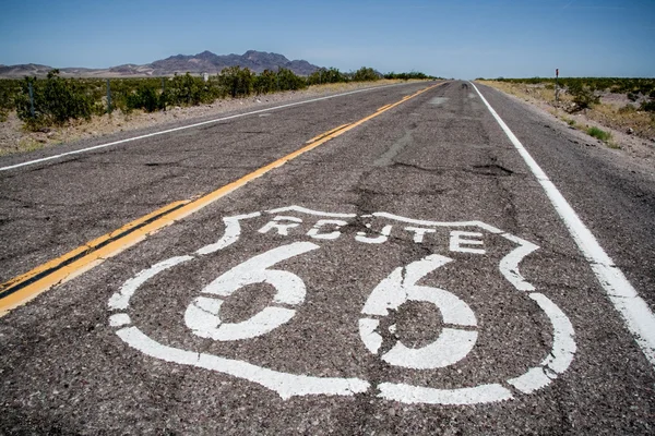 Route 66 oturum açma ile uzun bir yol üstüne boyayla Stok Fotoğraf
