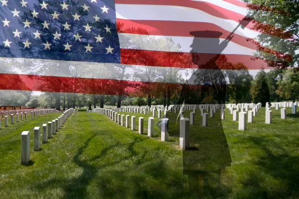 Soldatensilhouette, amerikanische Flagge und Grabsteine. Stockbild
