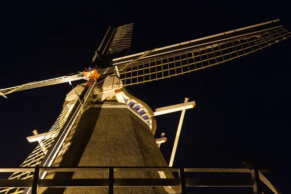 Vista nocturna del molino de maíz tradicional holandés iluminado con madera — Foto de Stock