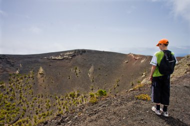 Boy near a big volcano at La Palma, Canary Islands clipart