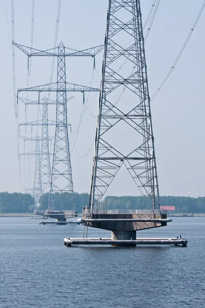 Fila de postes de energia no mar holandês — Fotografia de Stock