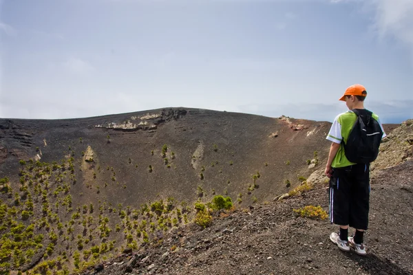 Jongen in de buurt van een grote vulkaan op la palma, Canarische eilanden — Stockfoto