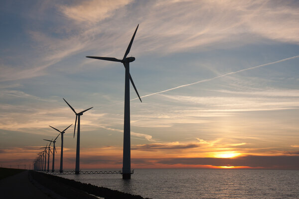 Голландские оффшорные ветряные турбины во время красивого заката
