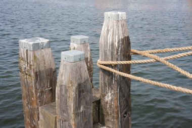 Wooden bollard with rope of tied ship clipart