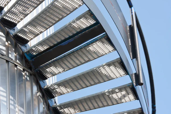 Escadaria de metal contra um céu azul brilhante — Fotografia de Stock