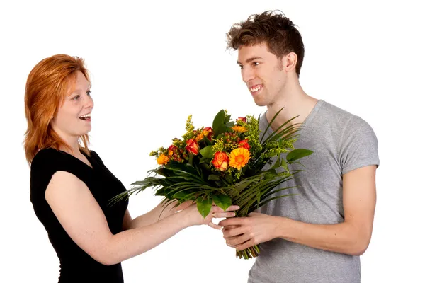 Ung man ger sin flickvän en stor bukett blommor — Stockfoto