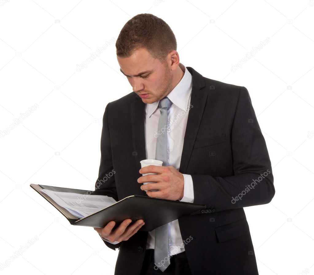 Businessman drinking coffee while reading his documents