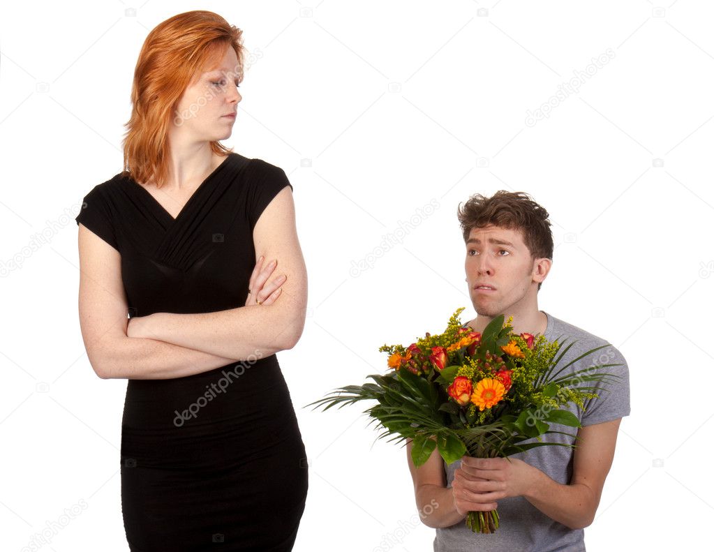 Young boy offering a bunch of flowers to his angry girlfriend