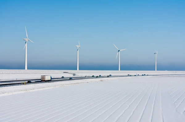 Nederländska landsbygdens vinterlandskap med en motorväg och stora windturbines — Stockfoto