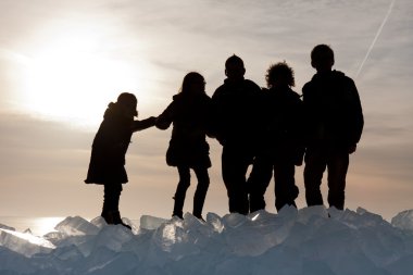 Silhouette of children on Ice hummocks at sunset in the Netherla clipart