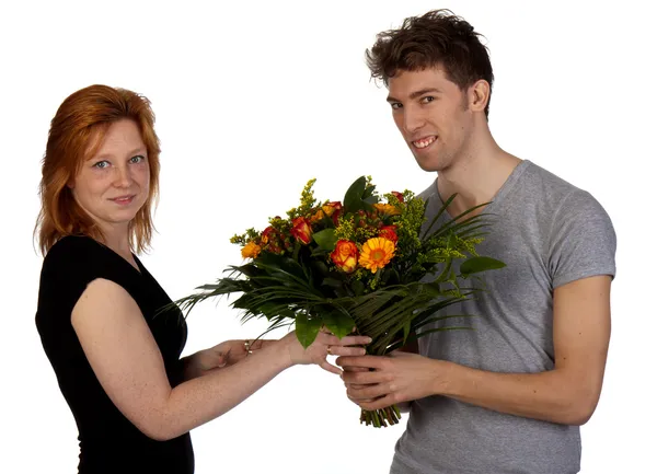 Ung man ger sin flickvän en stor bukett blommor, isola — Stockfoto