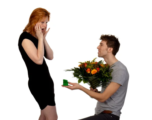 Junger Mann bietet seiner überraschten Freundin einen großen Blumenstrauß an — Stockfoto