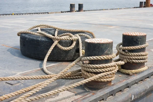 Понтон с боллардом, привязанный в гавани — стоковое фото