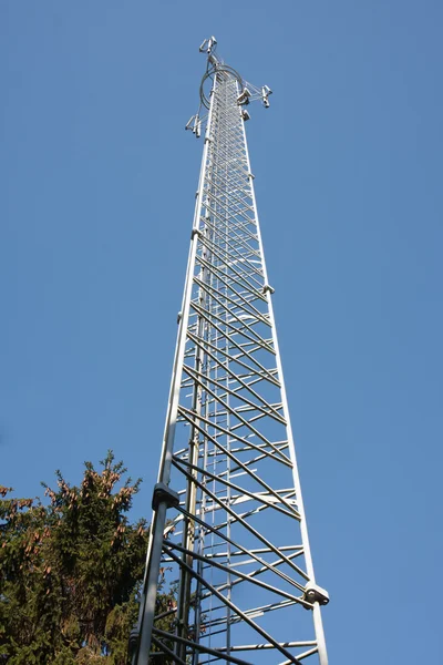 Kommunikasjonstårn i skogen med blå himmel – stockfoto