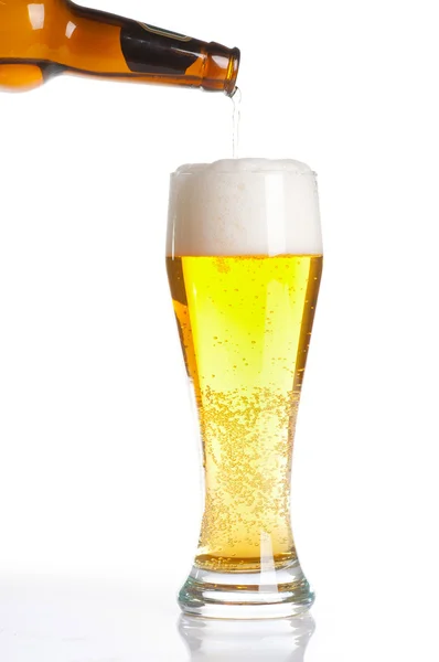 Öl som hälls från flaskan i glas isolerat på vitt — Stockfoto