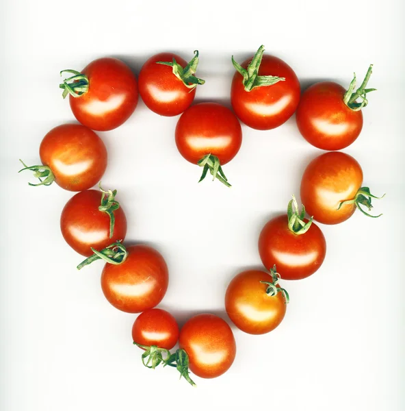 Heart shape made from cherry tomatoes over white background — Stock Photo, Image