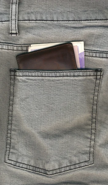 Plånbok halvvägs ut från en jeans bakficka — Stockfoto