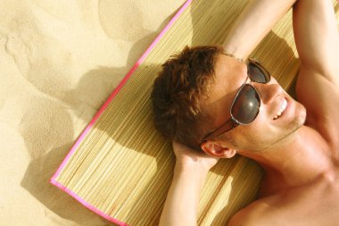 Man Sunbathing on the beach clipart