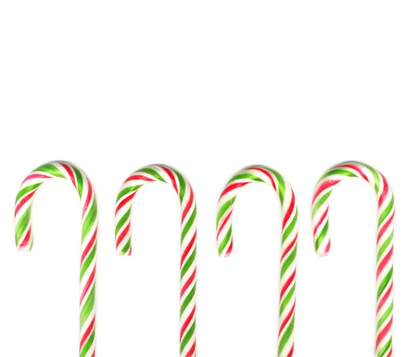 Cztery czerwone i zielone cukierki Boże Narodzenie biały na białym tle na laski — Zdjęcie stockowe